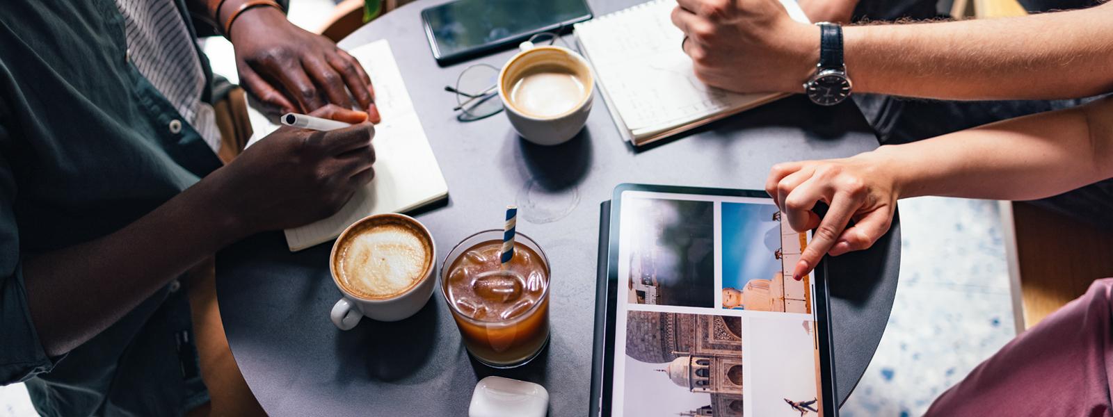 Top down image of people at a table planning a trip.