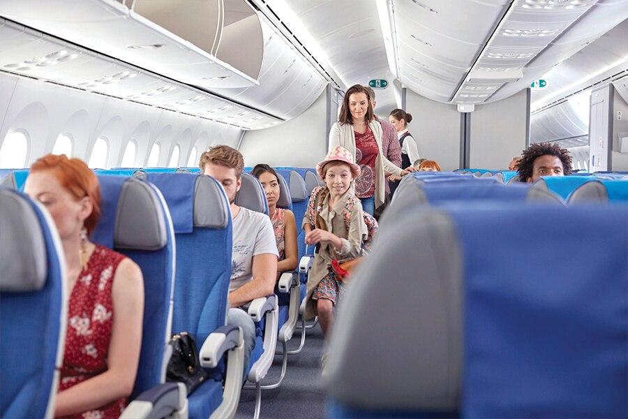 A group of people sitting on the seats of an airplane.