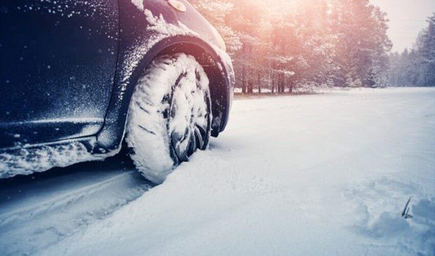 A car is parked on a snowy road.