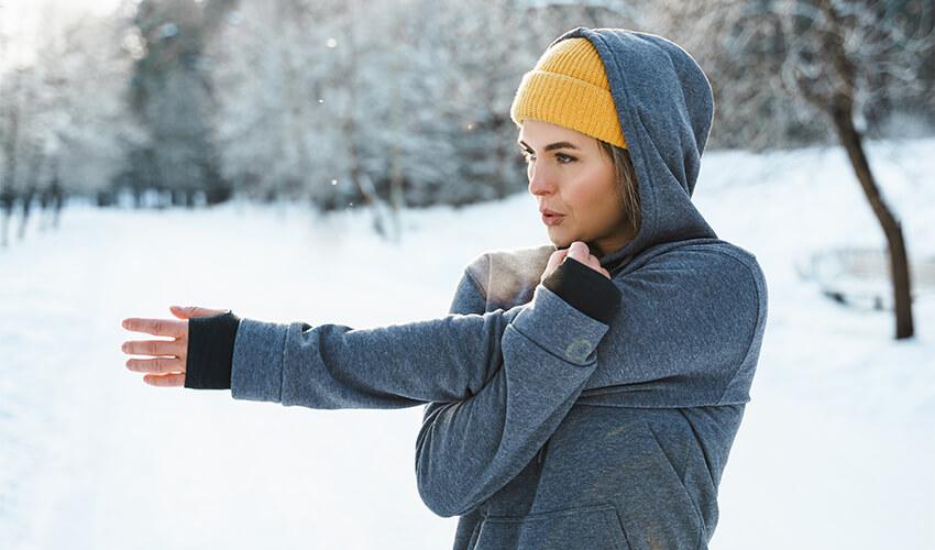 A woman wearing a hoodie in the snow.
