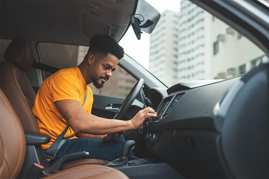 A man sitting in the driver's seat of a car.