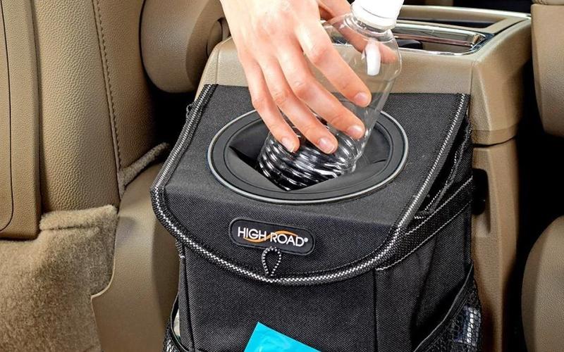 Small trash bin hanging into the center console of a car sco