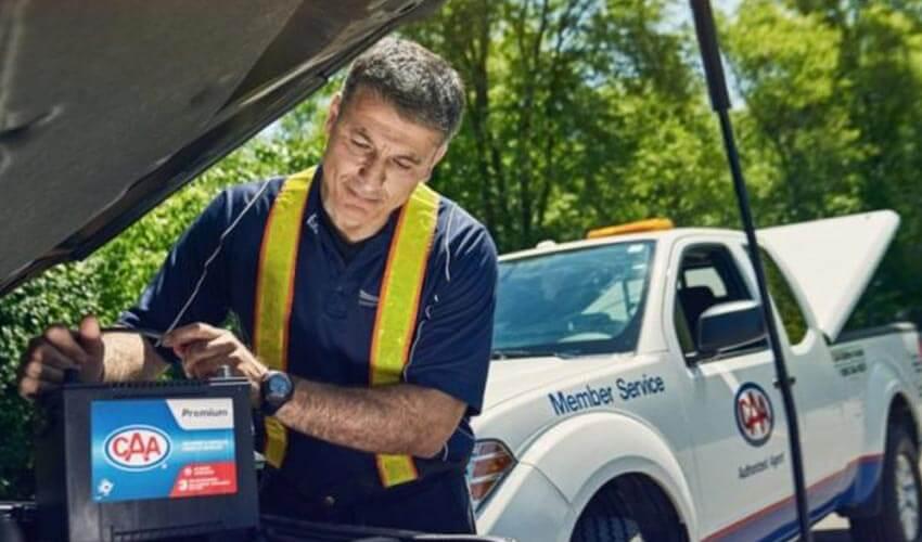 A man checking the battery of a truck.