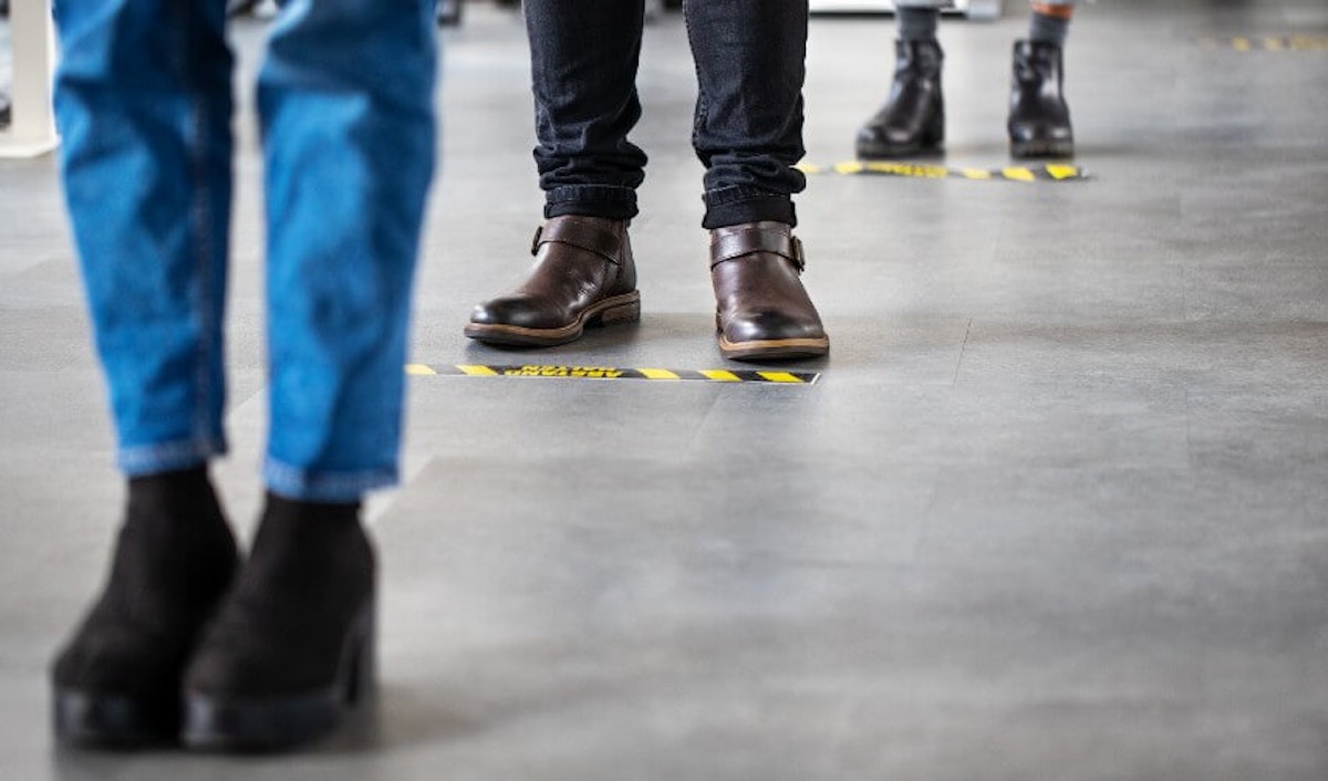 A group of people standing in a line of shoes.