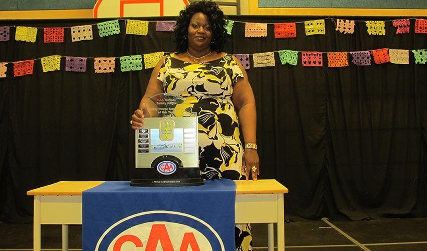 A woman standing in front of a table with a trophy.