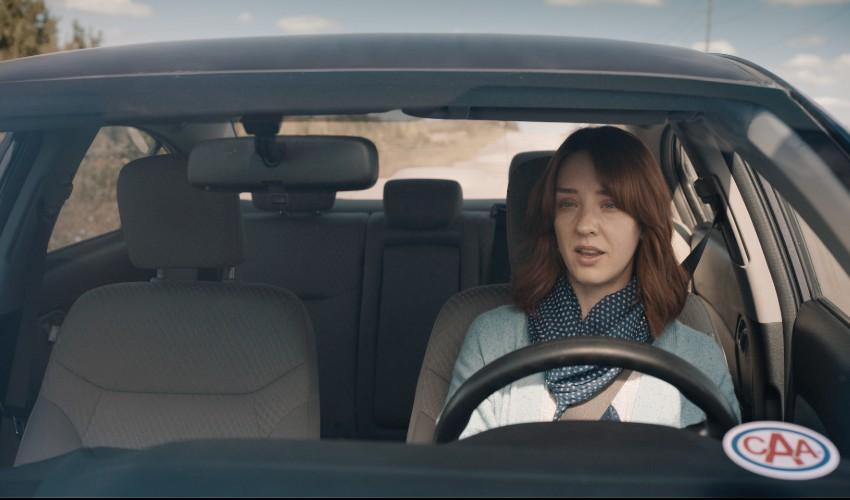 A woman sitting in the driver's seat of a car.