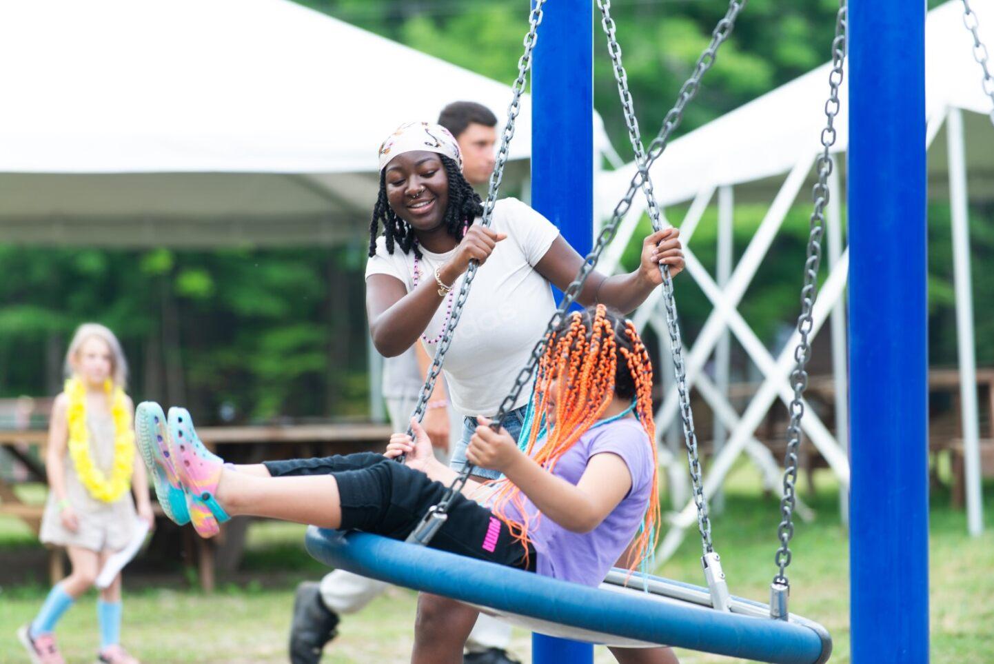 A young girl is swinging on a swing at a park.
