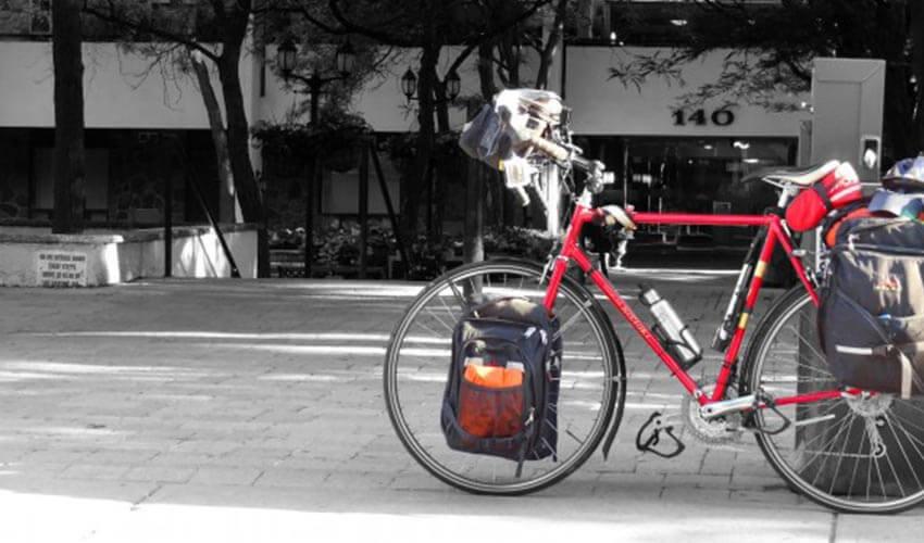 A red bicycle is parked on a sidewalk.