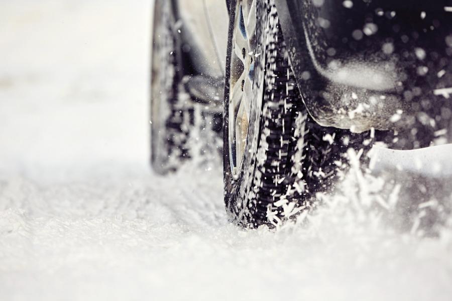 A black car driving on a snowy road.