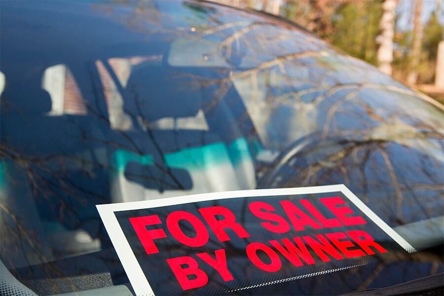 A car with a for sale by owner sign in the window.