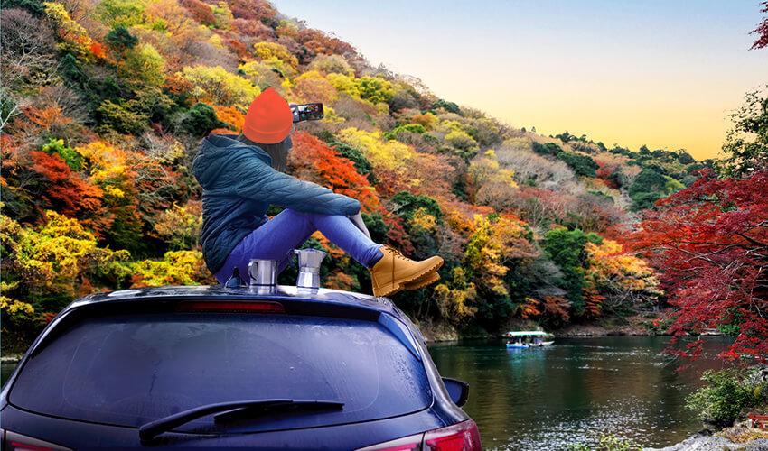 A person sitting on top of a car.