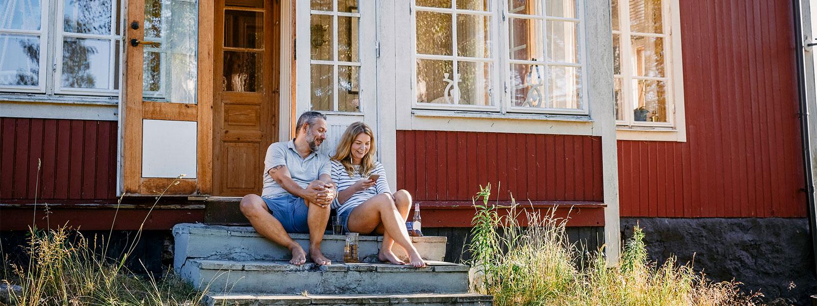 A couple sitting in front of a cottage.