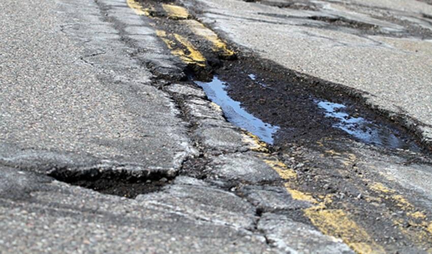 A road with a pothole in the middle of it.
