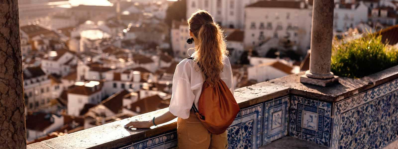 A female traveller overlooking a scenic viewpoint in Lisbon, Portugal.