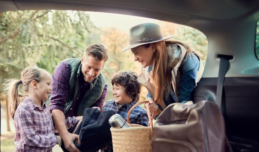 A family is getting ready to go on a vacation in a car.