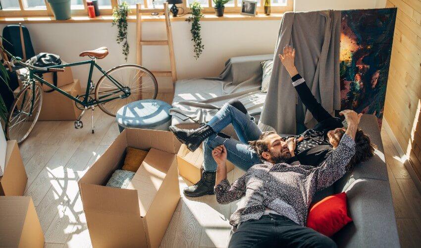A couple laying on the floor in their new home.