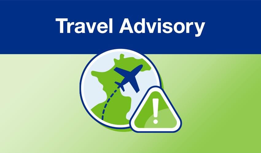 A green and blue sign with the words travel advisory on it.