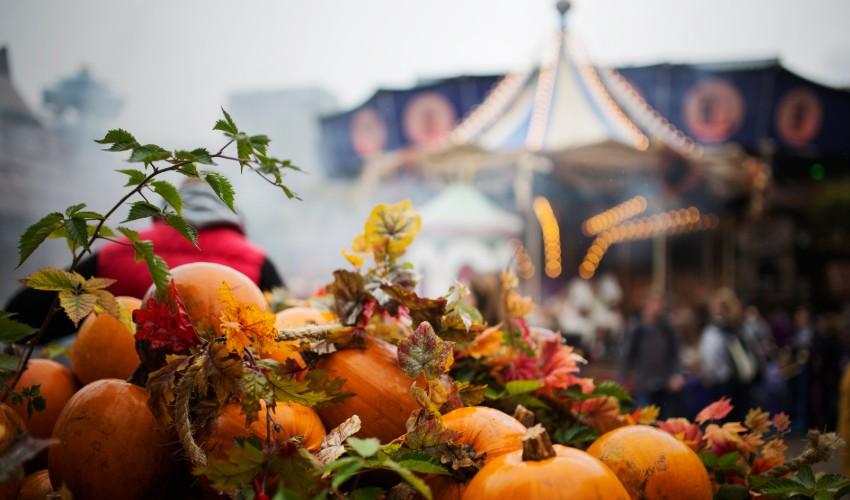 A carousel with pumpkins in front of it.