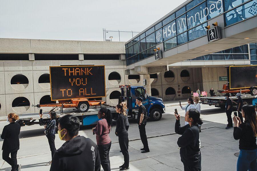 A group of people standing in front of a thank you sign.