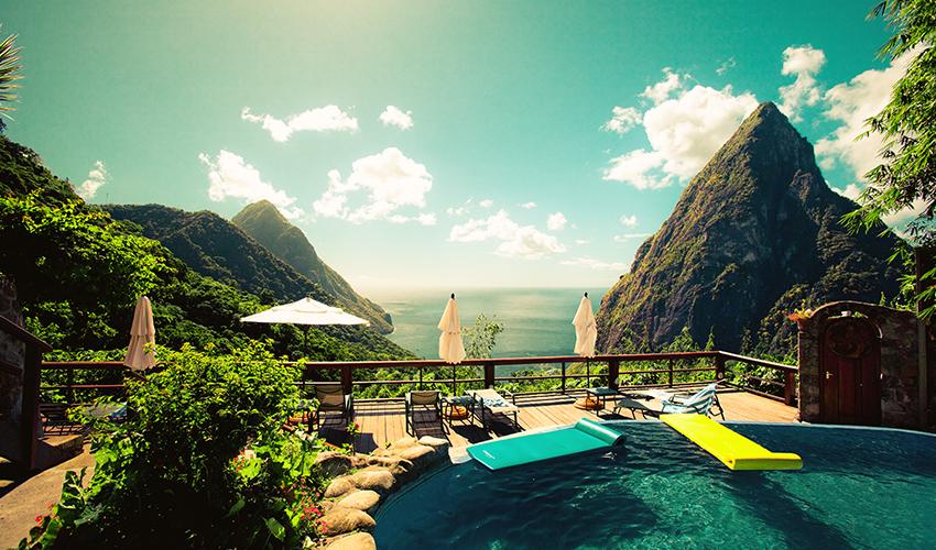 A pool with chairs and umbrellas overlooking a body of water.
