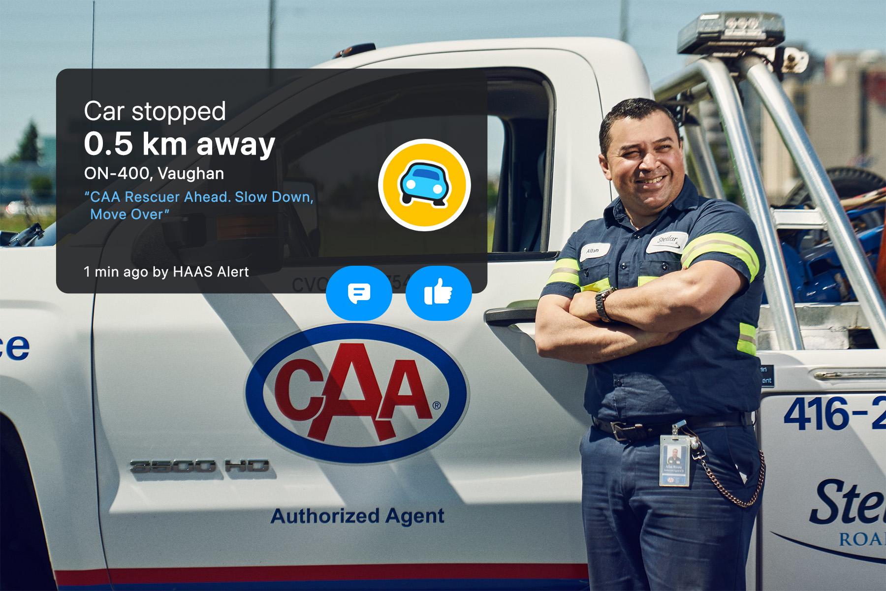 A service vehicle operator stands in front of the driver's side door of a CAA branded pickup truck.