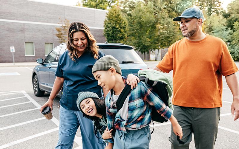 Family of four walking on a parking lot together