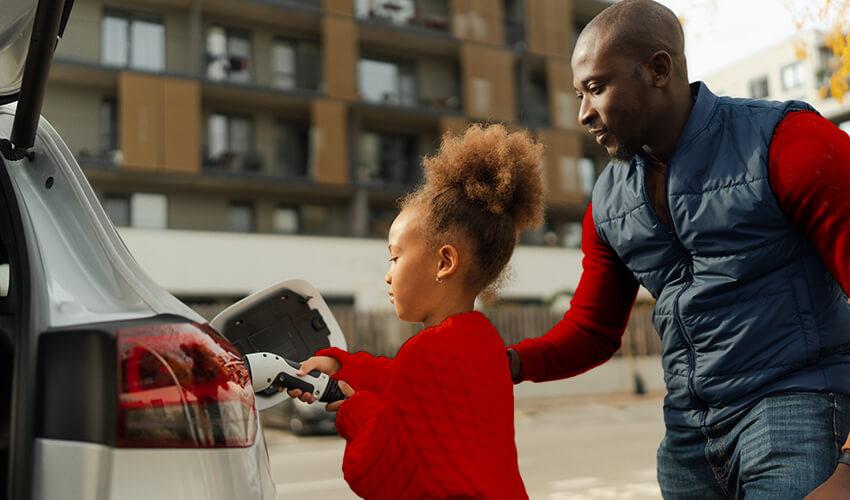A man and a little girl are putting gas in a car.