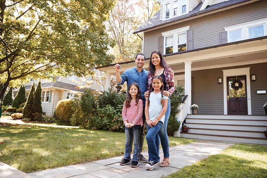 A family standing in front of a house.