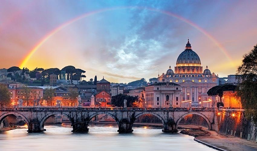 St peter's basilica in rome with a rainbow in the sky.