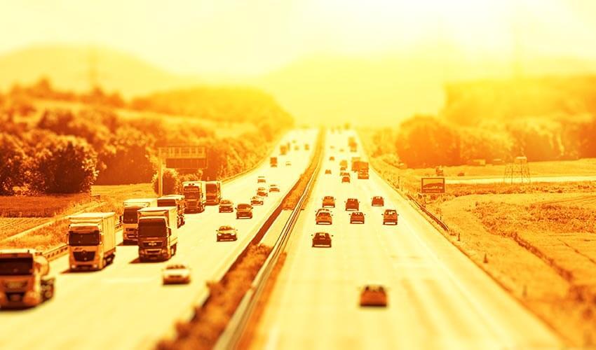 A blurry image of a highway with cars driving on it.