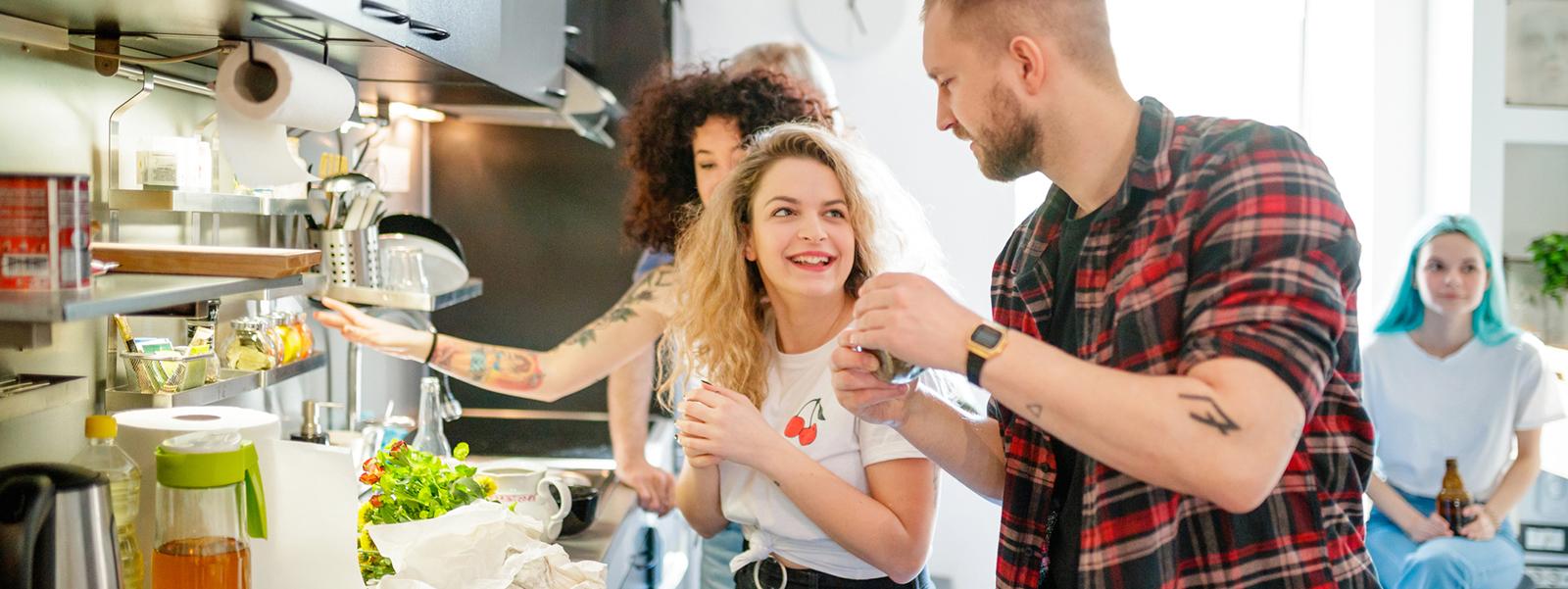 Group of friends in the kitchen making a meal together