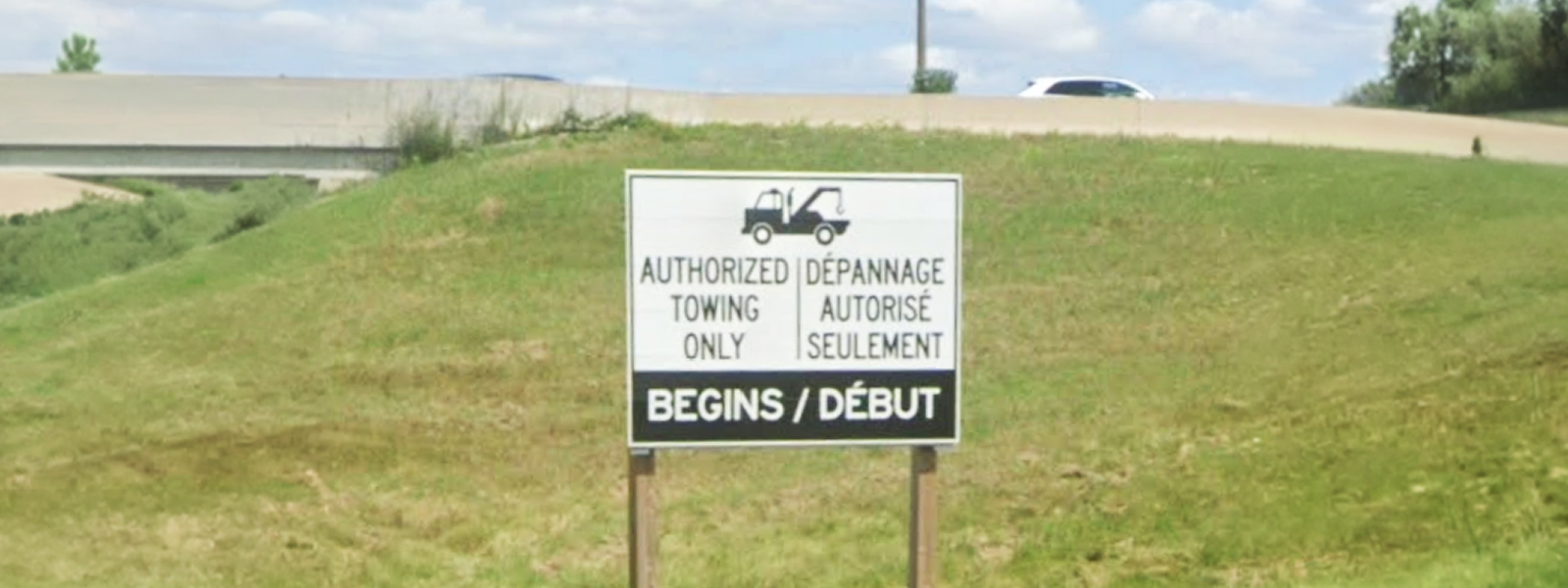 A sign on a grassy hall that says "Authorized Towing Only Begins"
