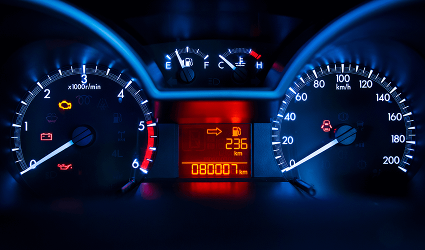 The dashboard of a car is lit up with blue lights.