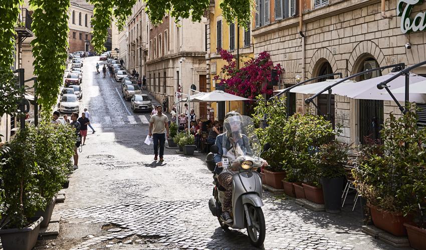A scooter is parked on a cobblestone street.