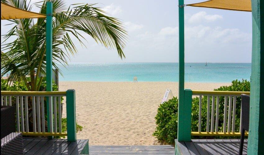 A view of the beach from the porch of a restaurant.