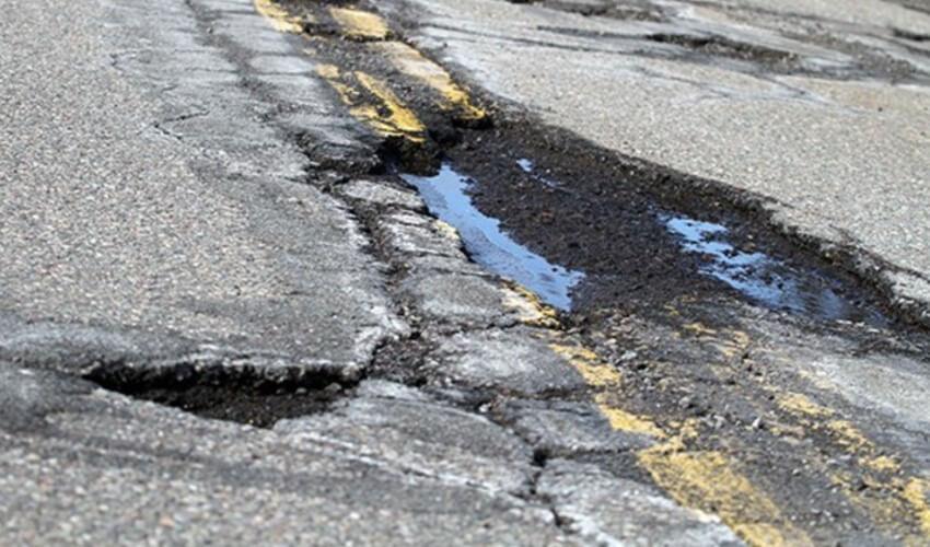 A road with a pothole in the middle of it.