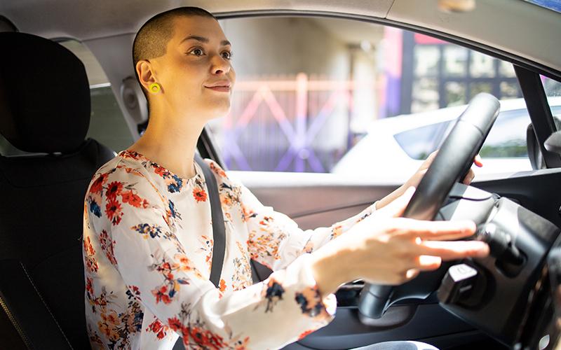 Woman holding steering wheel driving a car