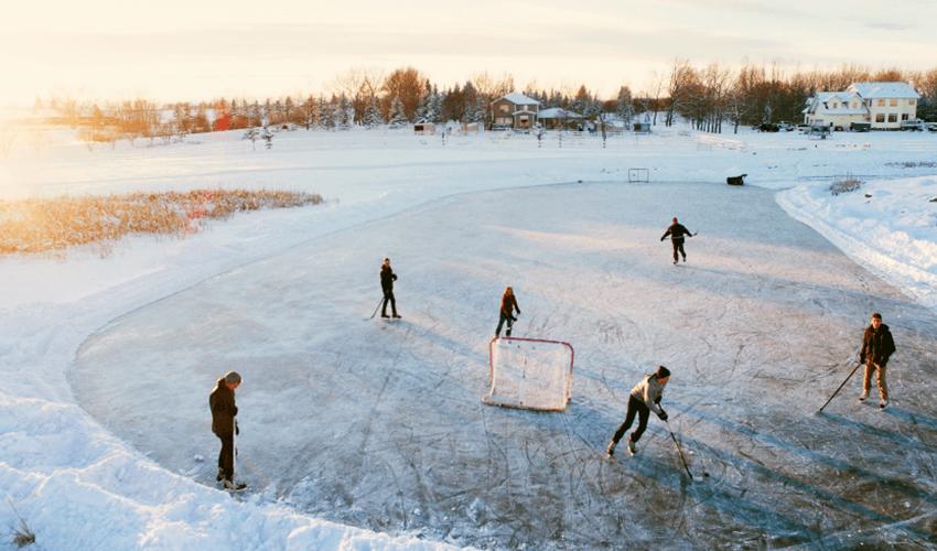A group of people playing ice hockey on an ice rink.
