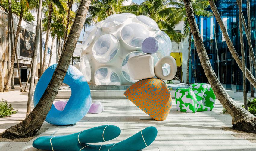 Modern art sculptures and installations in a tropical urban plaza.