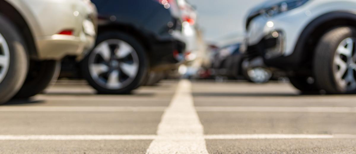 A blurry shot of vehicles lined up in a parking lot.
