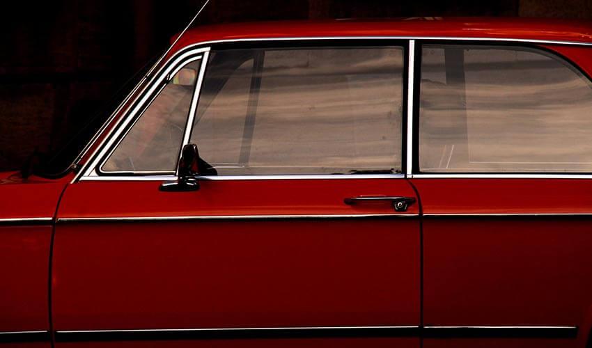 A red car parked in front of a building.