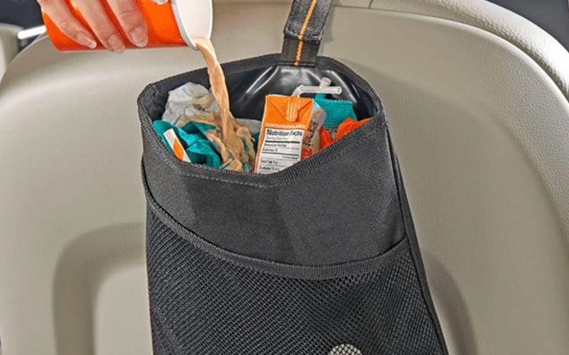 Small trash bin hanging into the backseat of a car mb