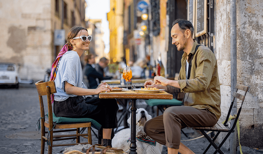 A man and woman sitting at an outdoor table.