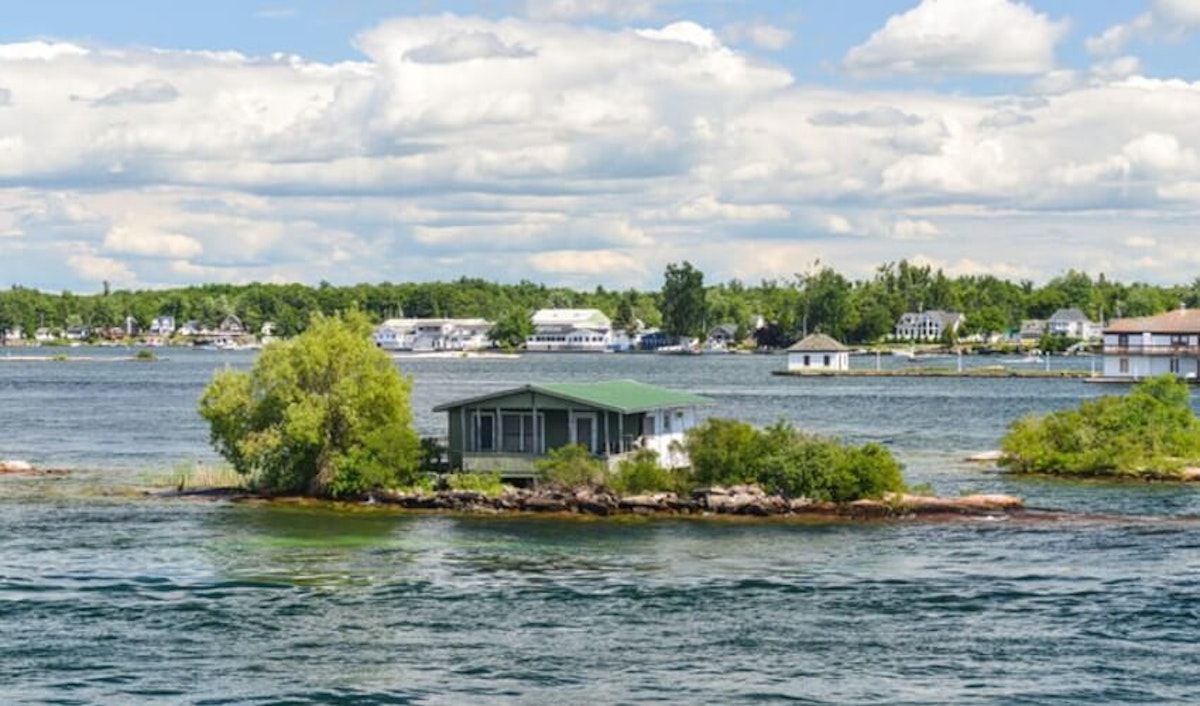 A house on an island in the middle of the water.