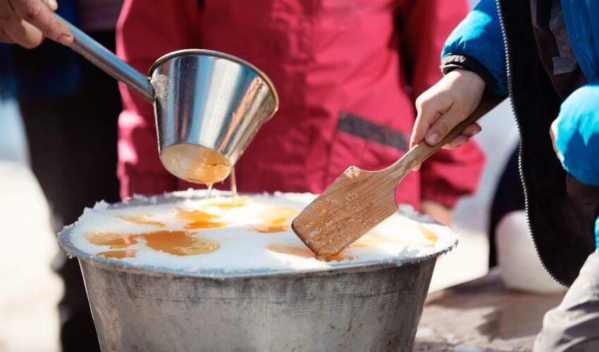 A person pouring ice cream into a bucket.