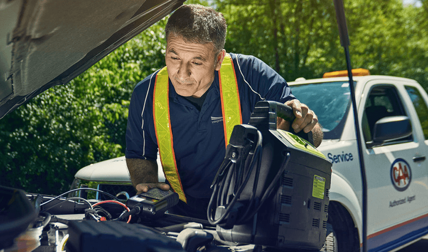 A man is working on a car battery.