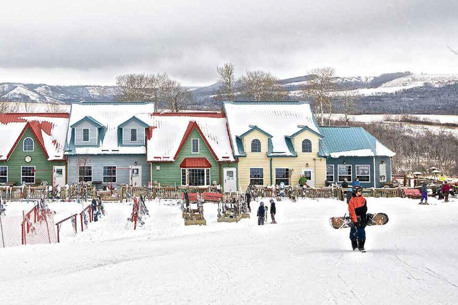 A group of people walking down a snow covered street.